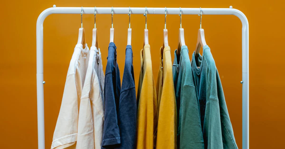 A row of colored garments hanging from a clothing rack
