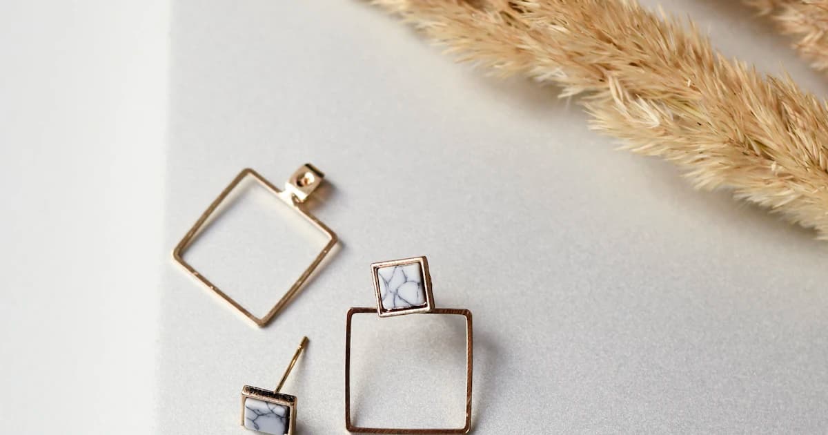 Geometric gold jewelry arranged on a light background