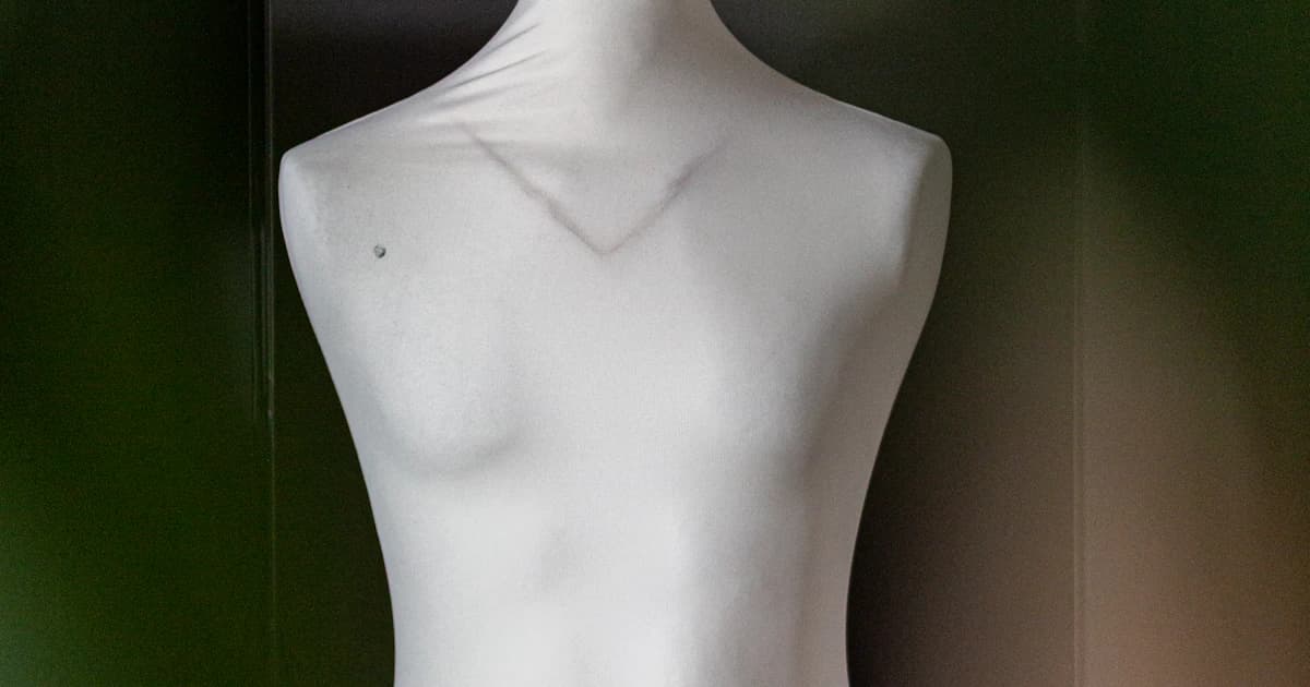 A white garment displayed on a dress form