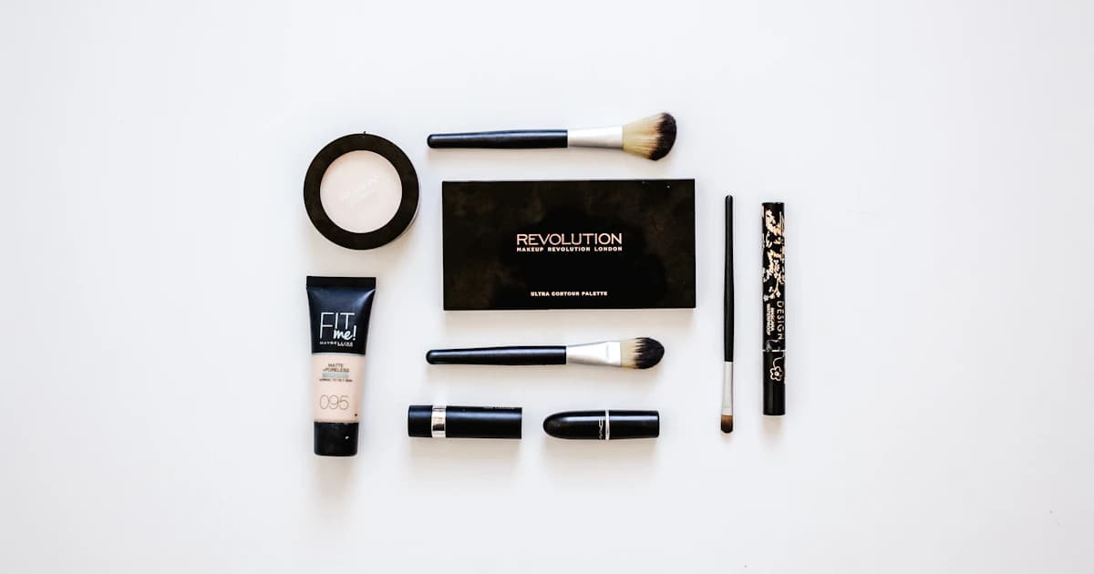 Cosmetics and brushes arranged on a white surface