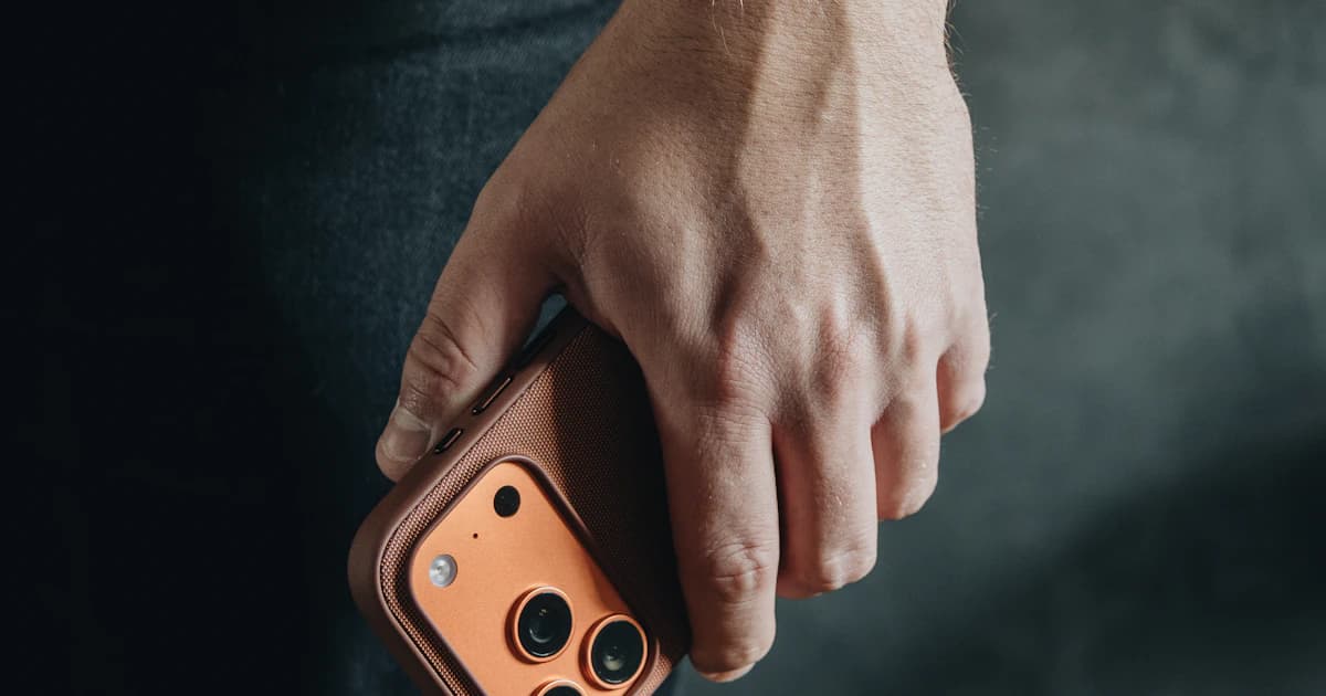 A hand holding a smartphone with a prominent camera module