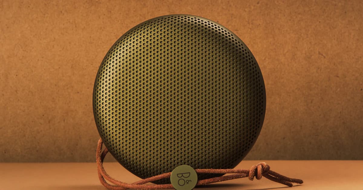 A round portable speaker photographed against a warm background