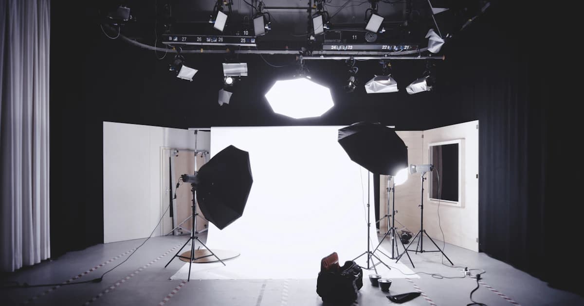 A photography studio with softboxes and a white backdrop